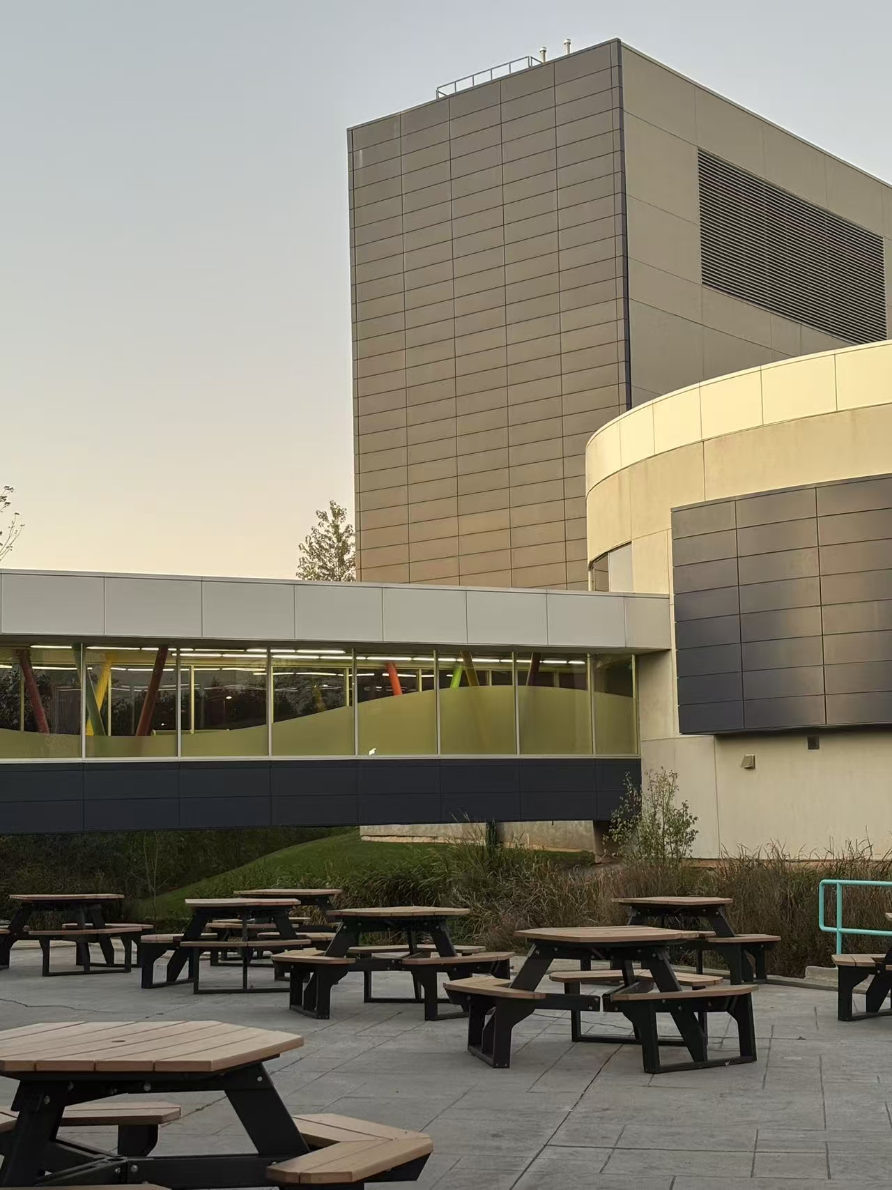 The location is outside the first floor of Building D, where students have meals and study. It offers a brighter and more open learning environment.<br>
Style: Modernism and industrial style<br>
Building materials: concrete, glass curtain wall, steel, wood, plants.